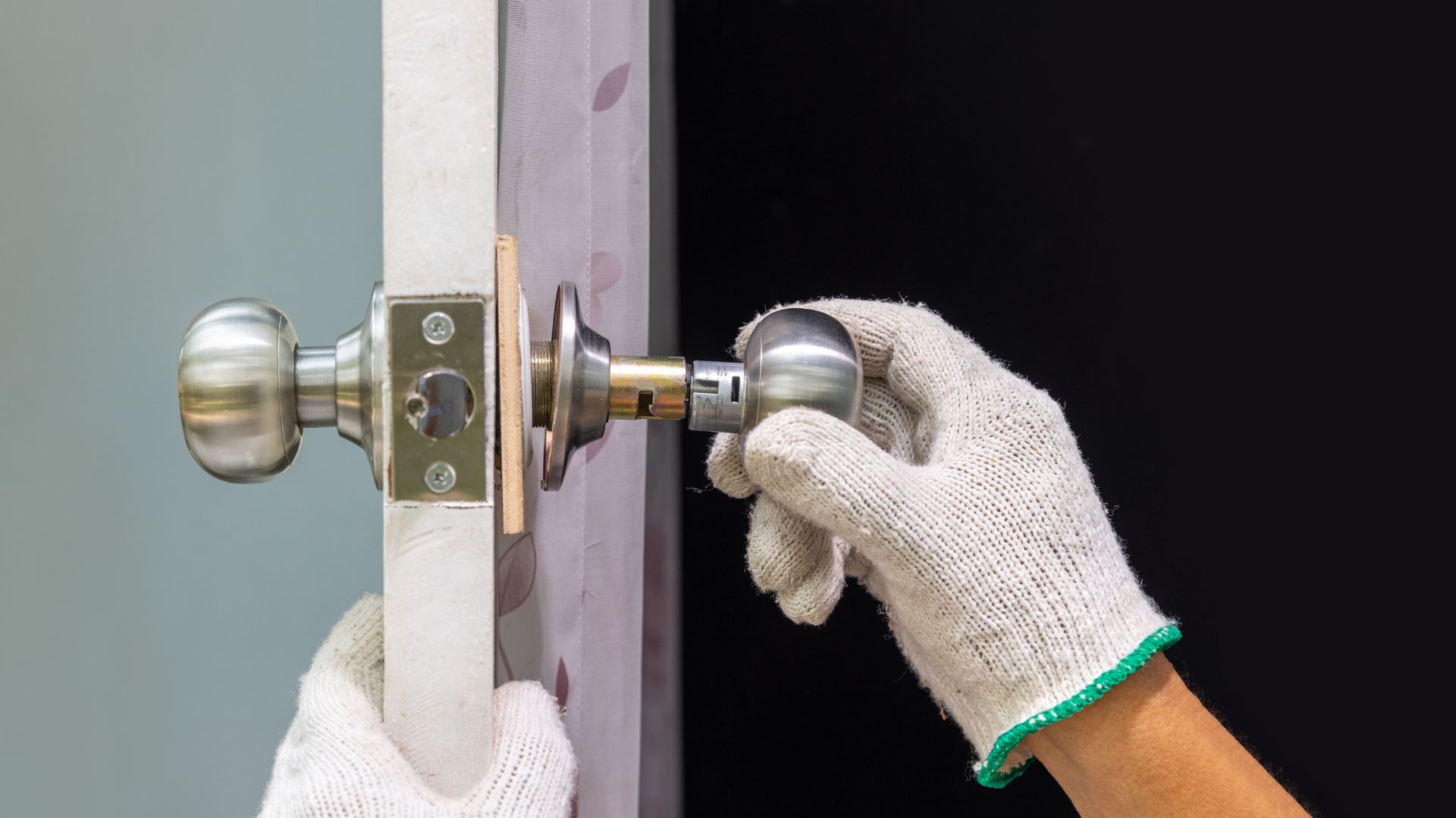 Residential locksmith services in Houston, Texas. A professional locksmith is installing or repairing a door knob with a key in a home. The technician is wearing gloves and working with precision to ensure secure and reliable home door locks.